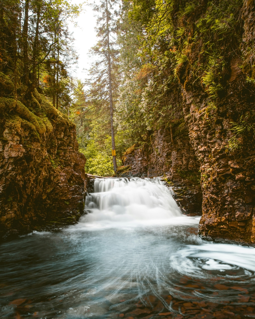 Waterfall in the Boundary Waters Canoe Area Wilderness Minnesota surrounded by forest a must for Minnesota outdoor activities lists and Minnesota travel blogs